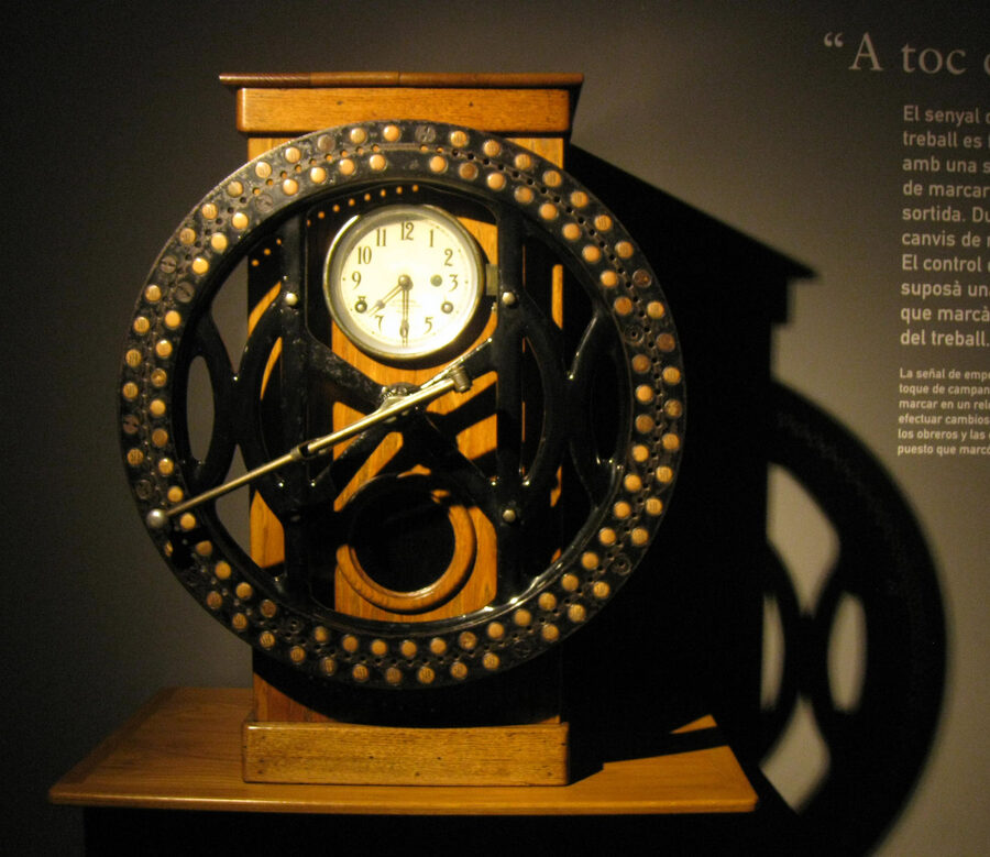 Reloj mecánico de fichar de una antigua fábrica textil, expuesto en un museo